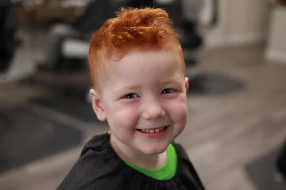 a boy with a fresh haircut smiling
